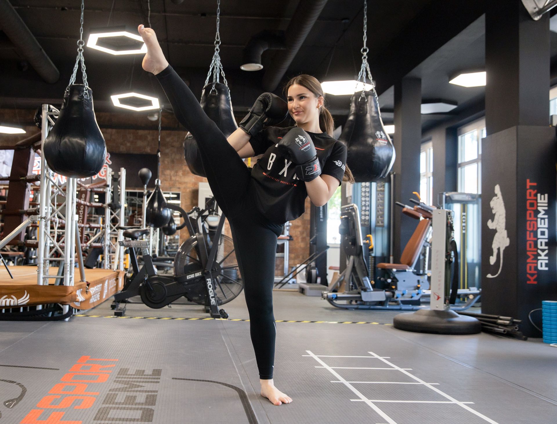 Erwachsene beim High-Kick-Training im Gerätebereich der Kampfsportakademie